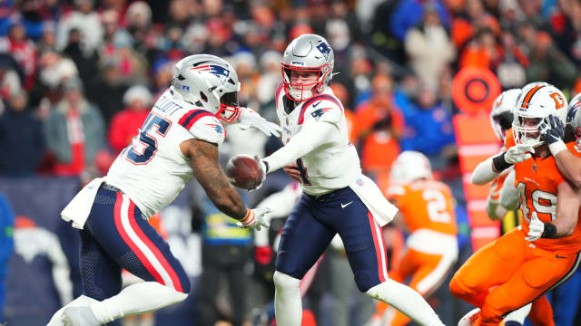 New England Patriots quarterback Bailey Zappe (4) hands off to running back Ezekiel Elliott (15) in the first quarter against the Denver Broncos at Empower Field at Mile High.